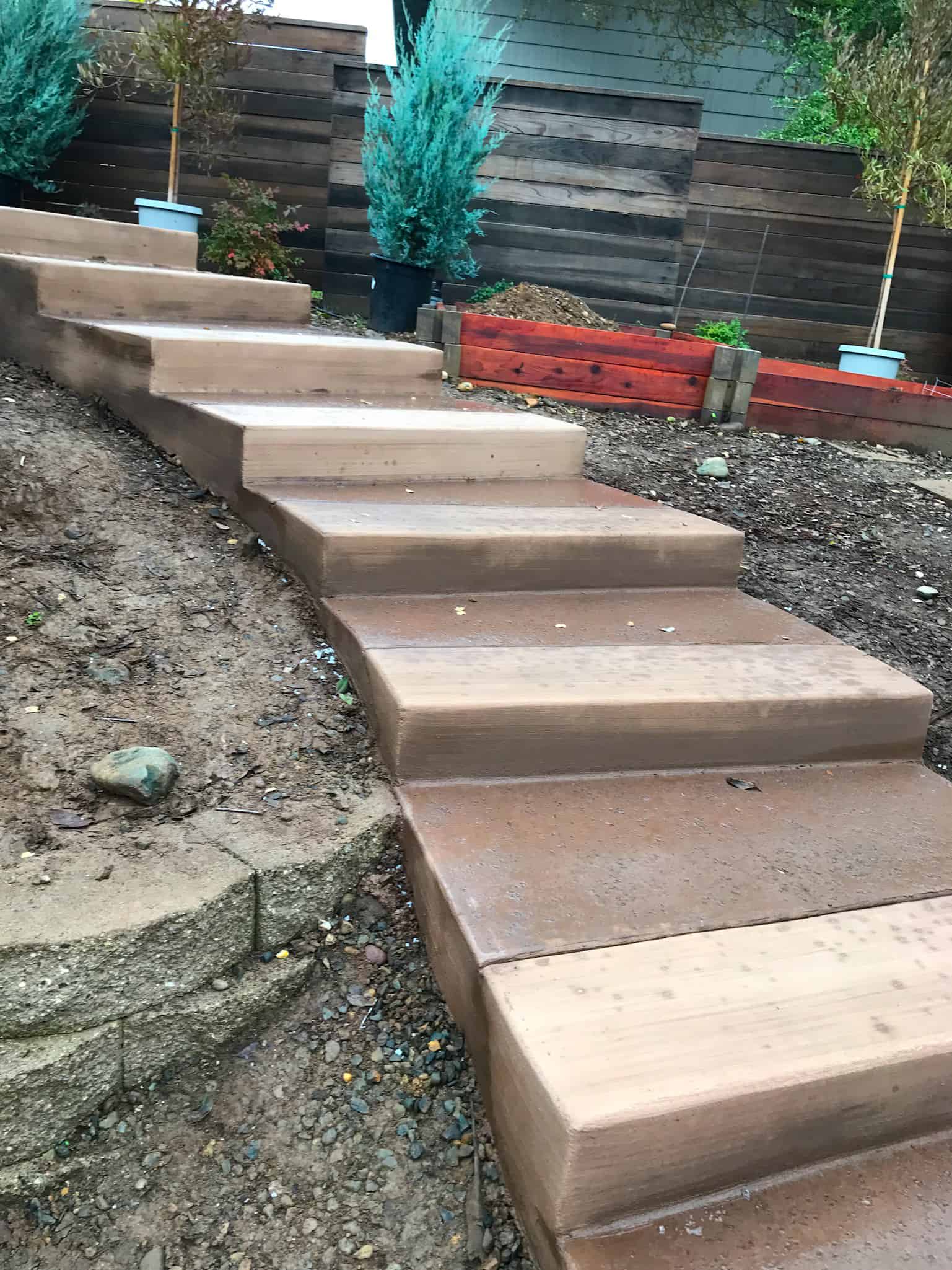 a stairs outside with a fence and a planter